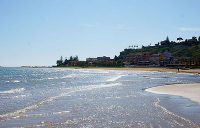 Beach by sea against sky in city