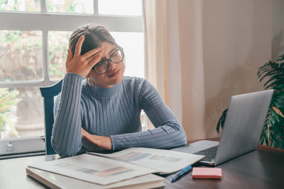 Young woman using laptop at home