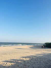 Scenic view of beach against clear blue sky