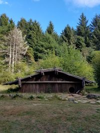 Built structure on field against trees in forest