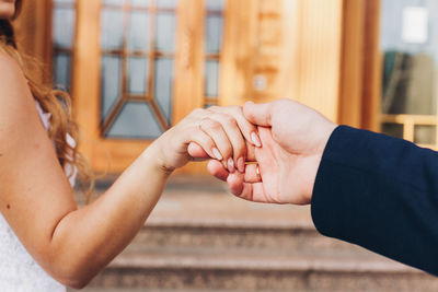 Cropped image of couple holding hands against steps