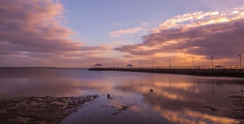 Scenic view of sea against cloudy sky at sunset