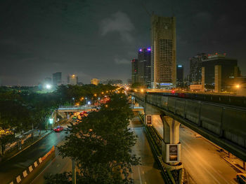 High angle view of illuminated street amidst buildings at night