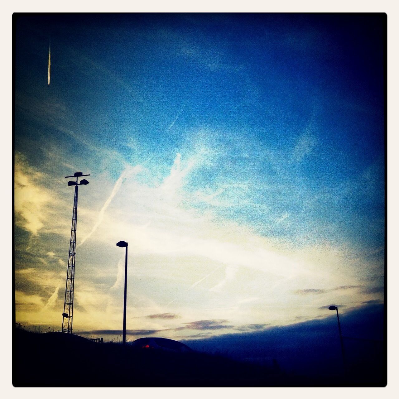 street light, low angle view, sky, transfer print, silhouette, lighting equipment, cloud - sky, electricity, auto post production filter, blue, cloud, power line, electricity pylon, nature, pole, tranquility, beauty in nature, dusk, scenics, outdoors