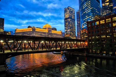 Bridge over river in city at dusk