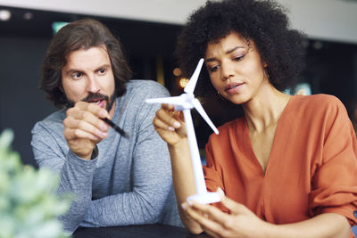 Business people discussing over windmill model