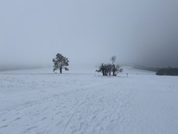 Scenic view of snow covered field against sky