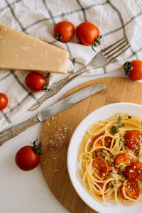 Flat lay portion of spaghetti pasta with cherry tomatoes sprinkled with spices