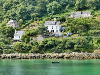 Scenic view of sea and buildings against trees