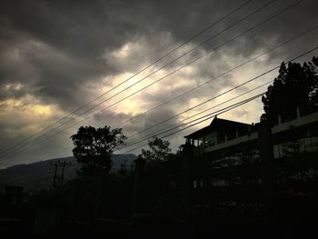 Low angle view of birds flying against cloudy sky