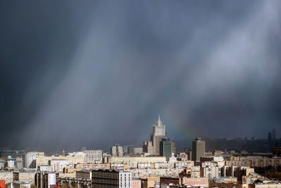 Buildings in city against cloudy sky