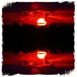 Close-up of illuminated fire against sky at sunset