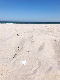Scenic view of beach against clear blue sky