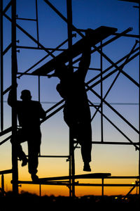 Low angle view of silhouette boy jumping against clear sky