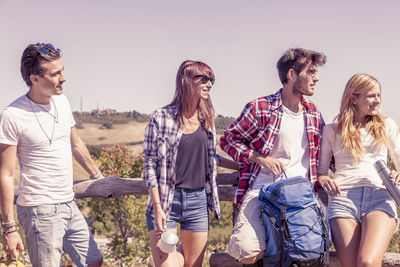 Rear view of friends walking on field