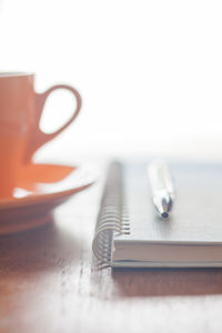Close-up of cup and book on table