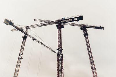 Low angle view of crane against sky