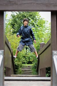 Portrait of smiling boy standing on railings over steps