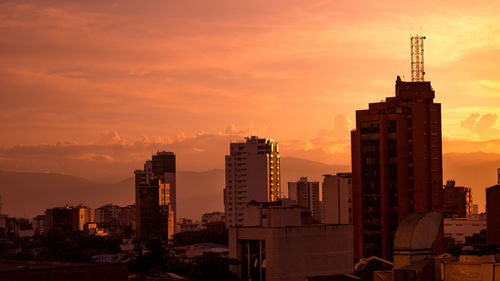 Modern buildings against sky during sunset