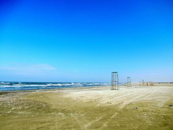Scenic view of beach against clear blue sky