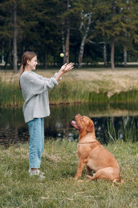 Man with dog standing on grass