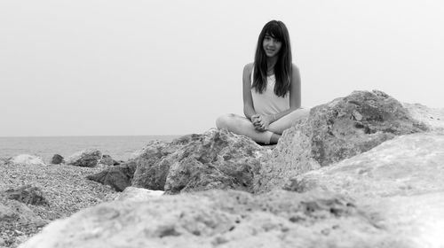 Portrait of woman sitting on rock formation