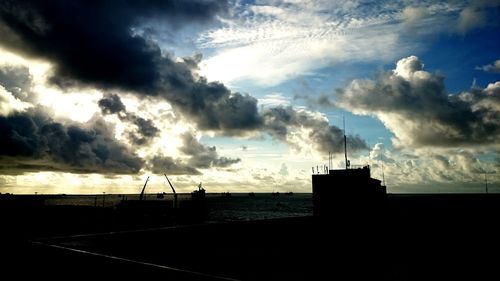 Silhouette of trees against cloudy sky
