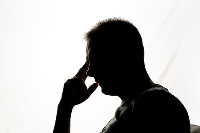 Close-up portrait of silhouette man against white background