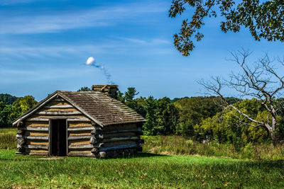 Barn on field against sky