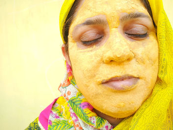 Close-up of mature woman with yellow facial mask