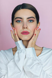 Portrait of a beautiful young woman pink background 