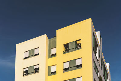 Low angle view of yellow building against sky