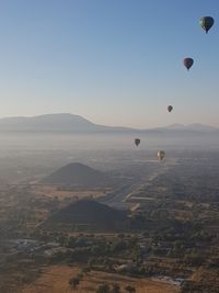 Scenic view of hot air balloons flying in sky