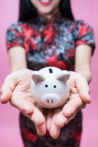 Midsection of woman holding piggy bank