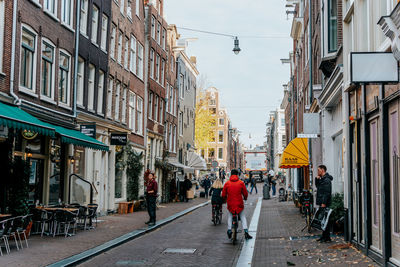 People walking on street amidst buildings in city