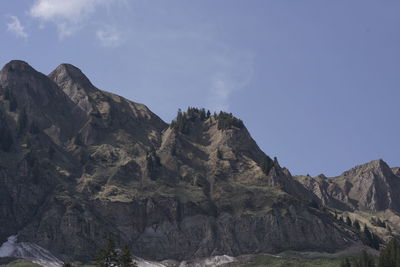 Low angle view of rocky mountains against sky