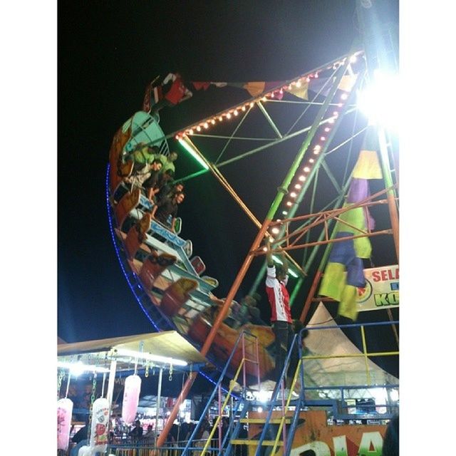 transfer print, amusement park, low angle view, amusement park ride, arts culture and entertainment, ferris wheel, auto post production filter, built structure, architecture, sky, clear sky, building exterior, fun, illuminated, night, outdoors, metal, no people, carousel