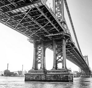 Low angle view of manhattan bridge over east river against sky