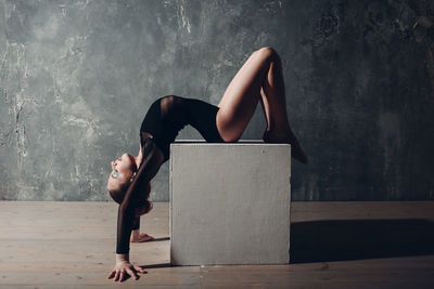 Side view of woman relaxing on wall