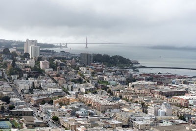 High angle view of townscape by sea against sky