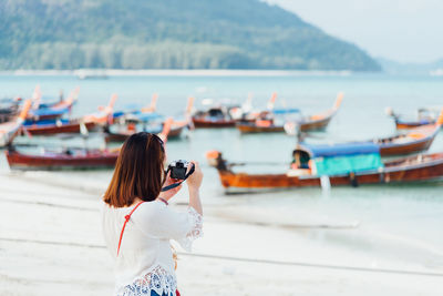 Rear view of woman photographing sea