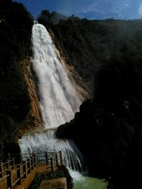 Scenic view of waterfall against sky