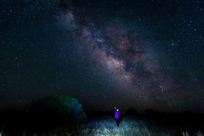 Woman standing on field against star field