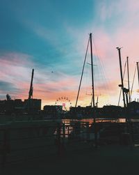 Silhouette harbor against sky during sunset