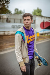 Portrait of young man standing on road