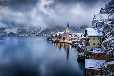 Scenic view of sea and mountains in town during winter