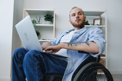 Portrait of young woman using laptop at home