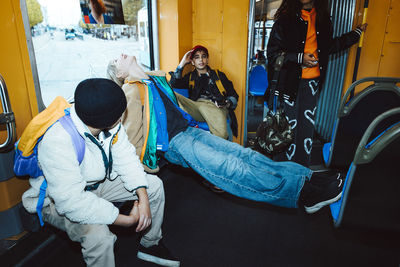 Multiracial male and female friends spending leisure time while traveling in tram