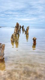 Rock formation in sea against sky