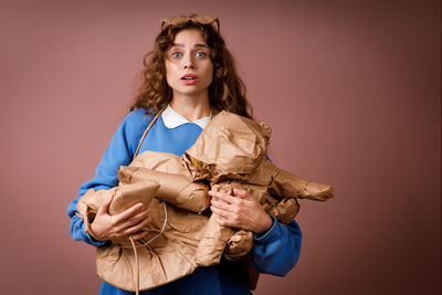 Portrait of young woman standing against white background